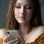 togliere visualizzato Instagram ragazza che guarda lo schermo smartphone curiosa